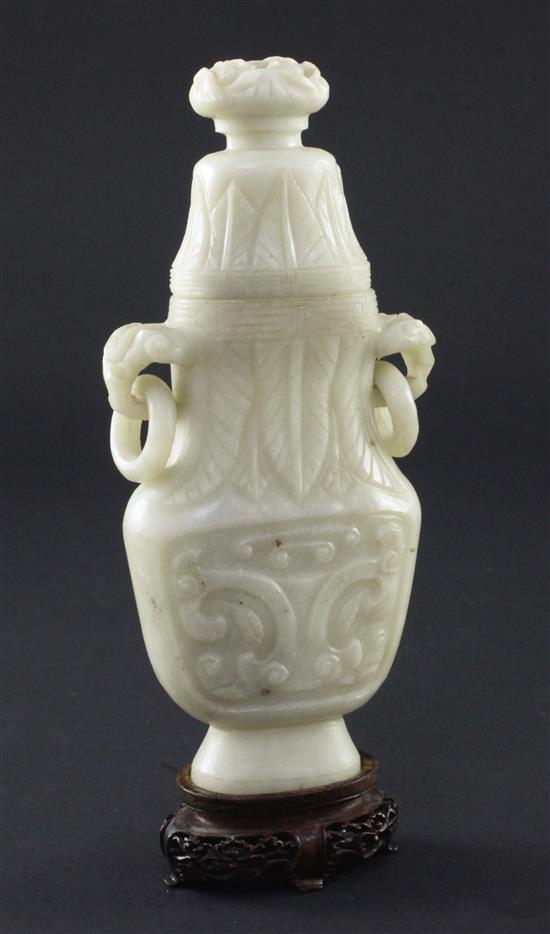 A Chinese greyish white bowenite jade archaistic vase and cover, 20th century, 17cm, wood stand